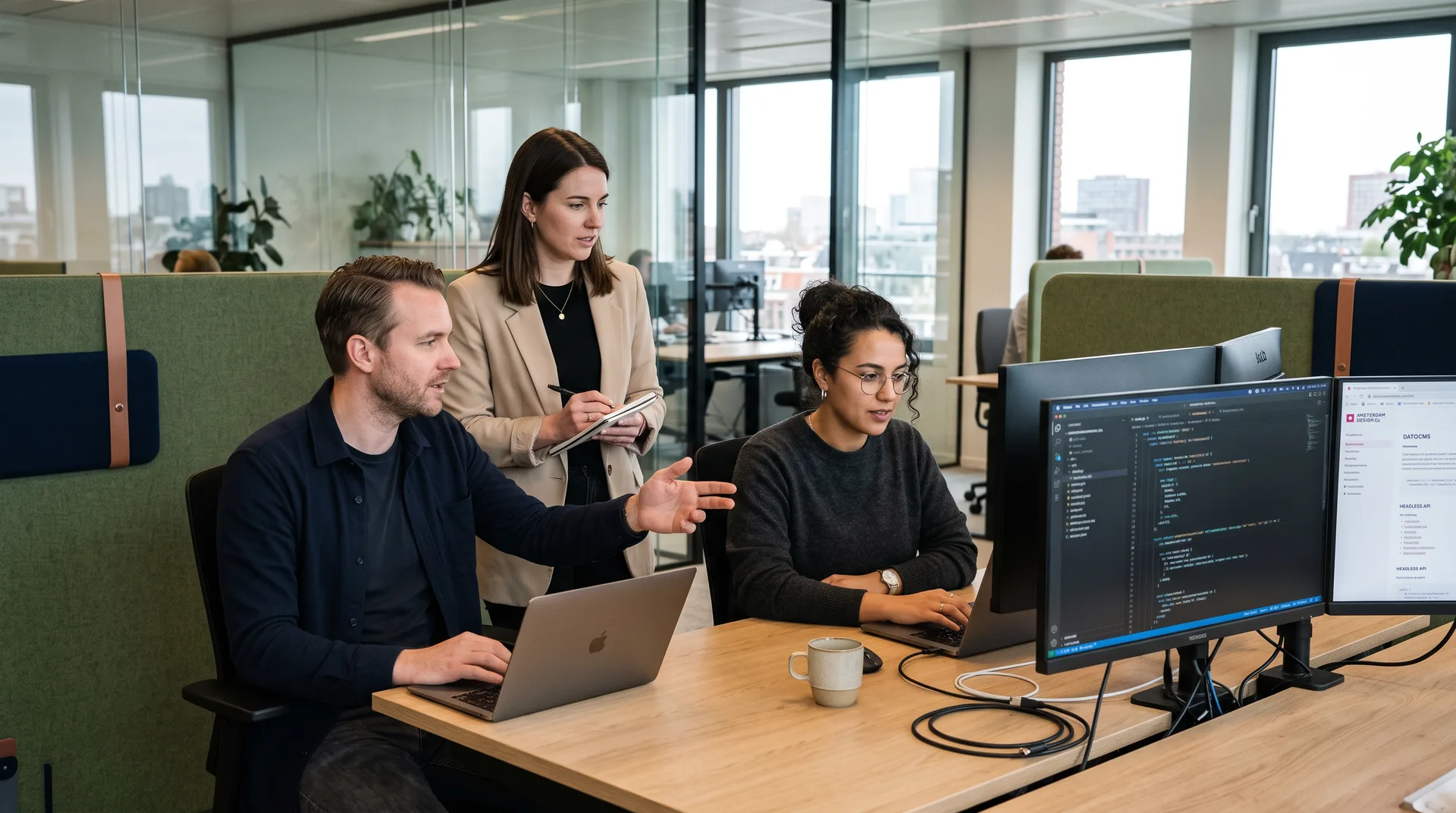 Developers van Webkompanen bespreken samen een codewijziging op het scherm tijdens een teamoverleg